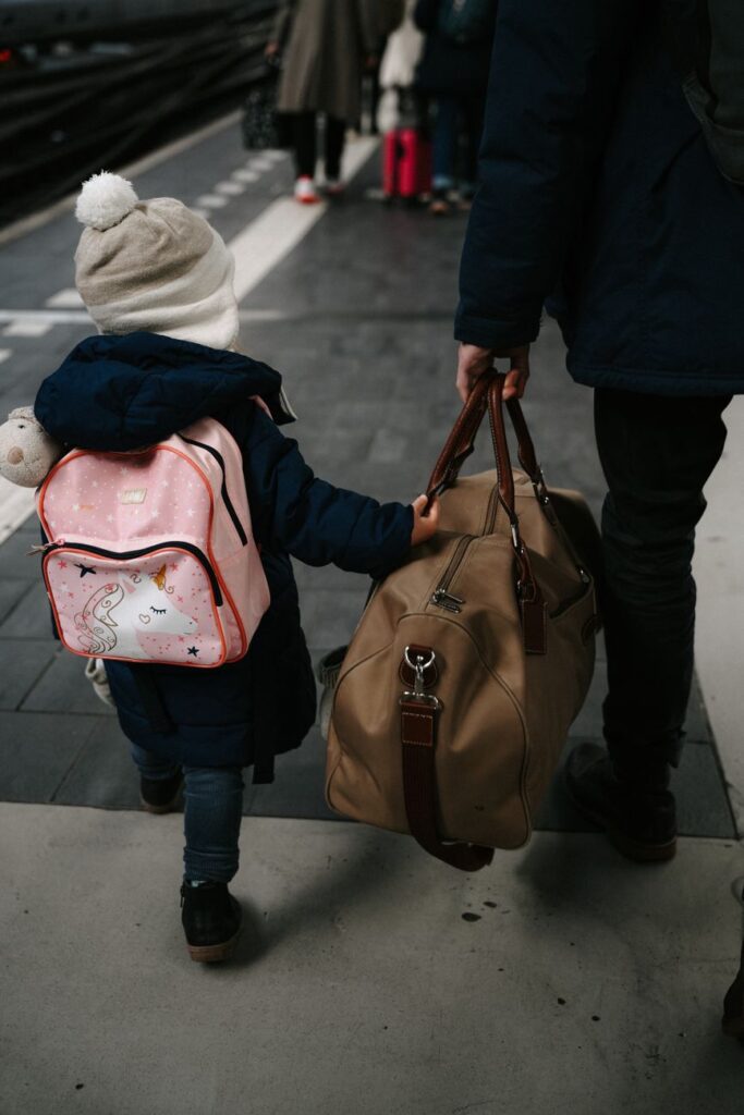 Child with parent at station in Amsterdam, perfect for travel themes.